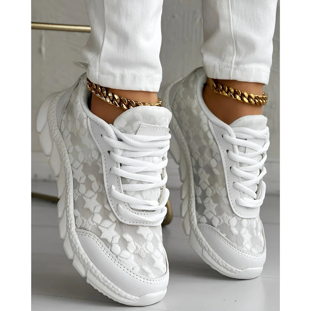 White platform sneakers with textured floral mesh and chunky lugged sole, worn with gold anklet