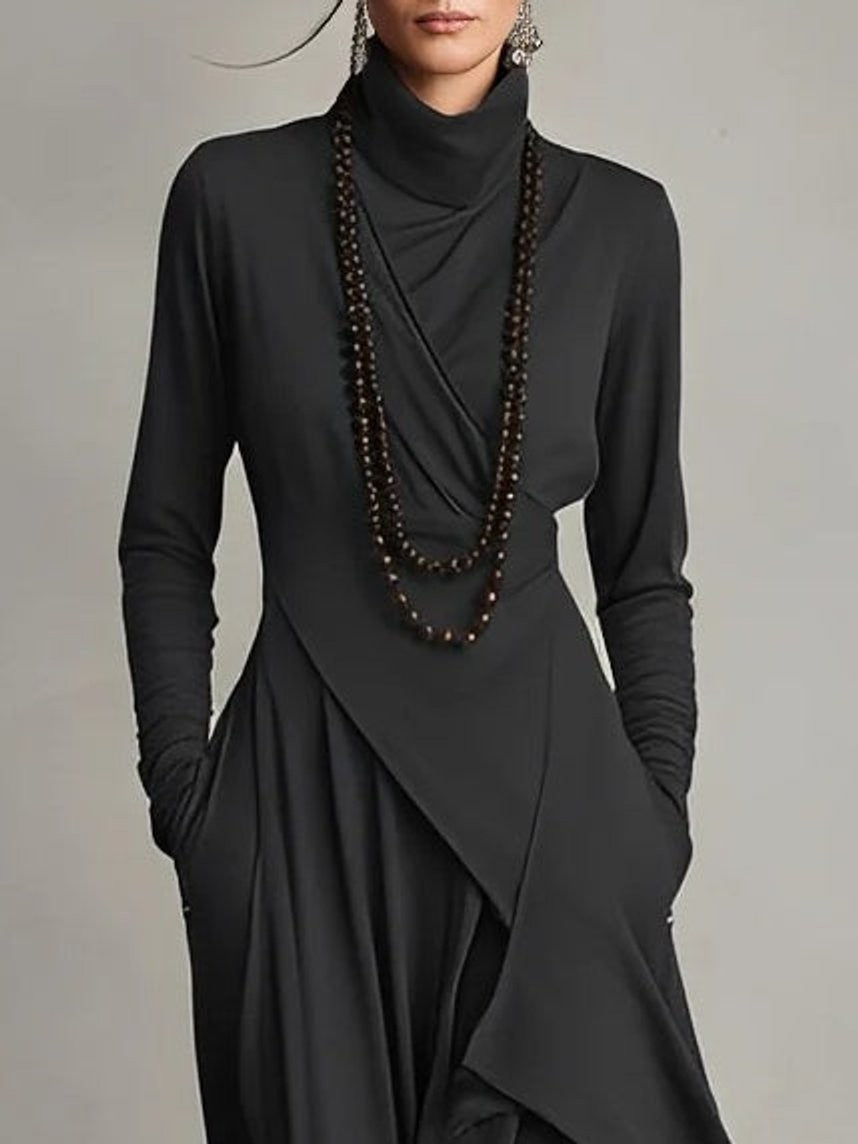 Close-up of black turtleneck dress with draped cowl neckline and beaded necklace
